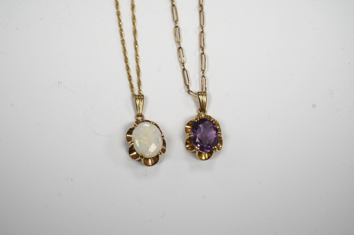 A modern 9ct gold and white opal set pendant, 21mm on a 14k chain, 46cm, gross weight 3.8 grams and a 9ct gold and amethyst set pendant on a yellow metal chain, gross weight 5 grams. Condition - fair